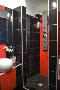 a black and red bathroom with a shower and a sink at Restaurace a penzion Lutena in Dolní Lutyně