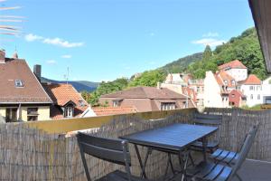 einen Tisch und Stühle auf einem Balkon mit Stadtblick in der Unterkunft Altstadtblick in Heidelberg