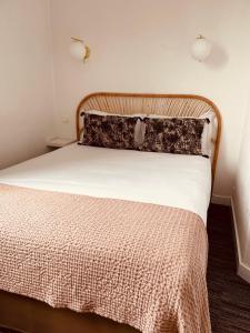 サン・マロにあるHôtel Le Britannic - centre gare-のベッドルーム1室(大型ベッド1台、木製ヘッドボード付)