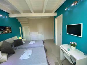 Una sala de estar con dos camas y un televisor. en Bnb Archimede, en Catania