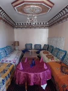 um quarto com duas camas com uma mesa em Room in Guest room - Gite Tawada - Haut-atlas - Room for 3 people em Agouti