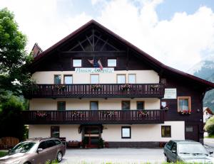 un edificio con balcone e auto parcheggiate di fronte ad esso di Pension Arnspitze a Scharnitz