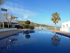 a swimming pool with blue water in front of a house at Residencial Itxaso 4/6 LEK in Peñíscola