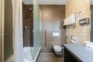 a bathroom with a shower and a toilet and a sink at Villa Fantasia Budget Boutique Hotel in Füssen