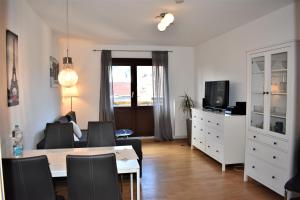 een woonkamer met een tafel en stoelen en een televisie bij Altstadtblick in Heidelberg