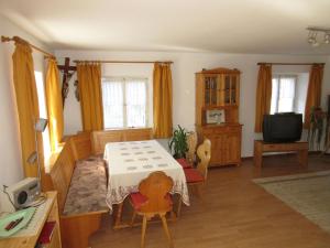 a living room with a table and a television at Hofgut Duerrenbuehl in Grafenhausen