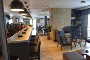 a restaurant with a long bar with chairs and tables at Apartman Grk 5 in Zlatibor