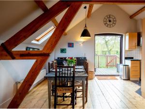 a kitchen and dining room with a table and chairs at Granary at Rectory Farm in Wolford