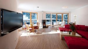 a living room with a red couch and a tv at Chalet & Apart Hochfügen in Hochfugen