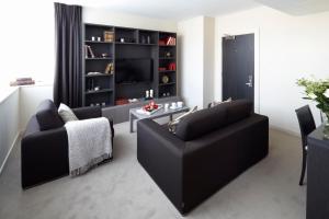 een woonkamer met een zwarte bank en een tafel bij Hotel Xanadu in Londen