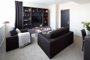 a living room with a black couch and a table at Hotel Xanadu in London