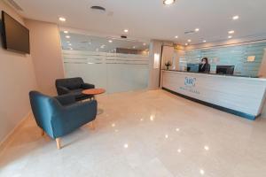 a waiting room with a blue chair and a counter at Hotel Monte Rozas in Las Rozas de Madrid