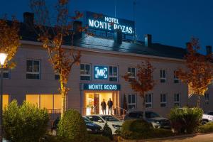 ラス・ロサス・デ・マドリードにあるHotel Monte Rozasのホテルの携帯薬を読む看板のある建物