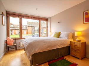 - une chambre avec un grand lit et une fenêtre dans l'établissement Granary at Rectory Farm, à Wolford