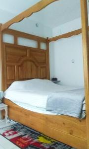 drewniane łóżko z drewnianą ramą w sypialni w obiekcie Maison d'une chambre avec wifi a Arques la Bataille w mieście Arques-la-Bataille