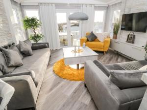 a living room with two couches and a table at 23 Valley View in Morpeth