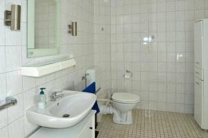 uma casa de banho branca com um WC e um lavatório em Ferienwohnung Roessing 25194 em Bunde