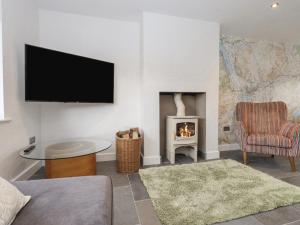 a living room with a fireplace and a flat screen tv at Woodview in Pooley Bridge