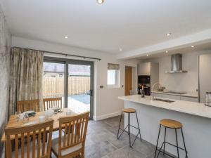 a kitchen and living room with a table and chairs at Woodview in Pooley Bridge