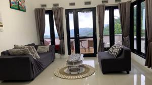 a living room with two couches and a table at Villa Kay Kay Mountain in Bogor