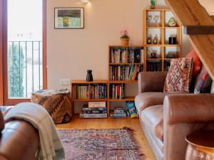 ein Wohnzimmer mit Sofa und Bücherregal in der Unterkunft Granary at Rectory Farm in Wolford