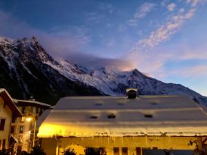 una montaña cubierta de nieve frente a un edificio en Le Gypaète en Chamonix-Mont-Blanc