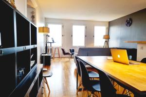 a living room with a table with a laptop on it at Vue Panoramique sur la Baie de Seine Parking in Honfleur