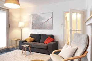 ein Wohnzimmer mit einem Sofa und einem Stuhl in der Unterkunft Ferienwohnung Speldorf in Mülheim an der Ruhr