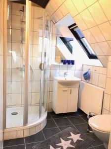 グドイェムにあるGudhjem unsere Ferienwohnung mit tollem Meerblickのバスルーム(シャワー、洗面台、トイレ付)