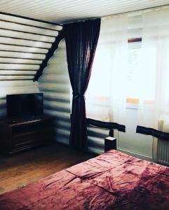 a bedroom with a bed and a window at У Віти котедж 1 in Synevyrsʼka Polyana