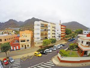 une ville avec des voitures garées dans une rue avec des bâtiments dans l'établissement Apartamento La Paella de Bajamar, à Bajamar