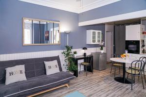 ein Wohnzimmer mit einem Sofa und einem Tisch in der Unterkunft Le Pyrénées - Bel appartement à proximité des Halles - Parking in Pau