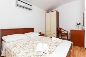 a bedroom with a bed with two towels on it at Apartments Ana in Lopud Island