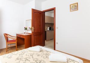 1 dormitorio con cama, escritorio y espejo en Apartments Ana, en Lopud Island