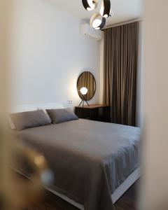 een slaapkamer met een bed en een spiegel bij Kostjukowski Apartments Forum in Lviv