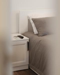 a bed with a white nightstand next to a bed sidx sidx sidx at Kostjukowski Apartments Forum in Lviv
