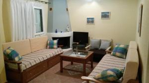 Sala de estar con 2 sofás y mesa en Appartamenti Angelika, en Perdika