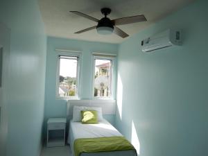 a bedroom with a bed and a ceiling fan at Oistins Bayview Apartments in Christ Church