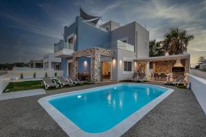 a house with a swimming pool in front of it at Tamaris Villa in Mastichari