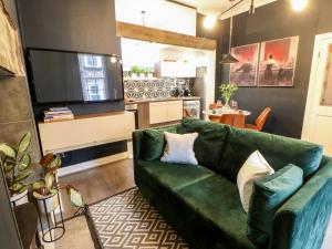 a living room with a green couch and a television at Jaipur House in Richmond