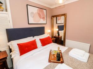 a bedroom with a bed with red pillows and a mirror at Jaipur House in Richmond