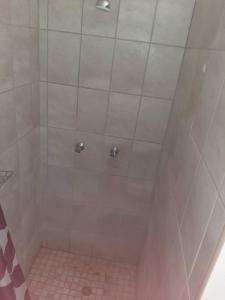 La salle de bains est pourvue d'une douche et de carrelage rose. dans l'établissement OrbanLife Lite Keetmanshoop, à Keetmanshoop
