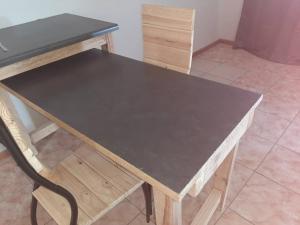 a wooden table with a black top and a chair at OrbanLife Lite Keetmanshoop in Keetmanshoop