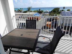 a table and chairs on a balcony with a view of the ocean at Oistins Bayview Apartments in Christ Church