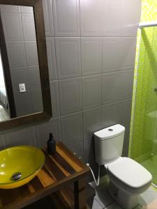 a bathroom with a toilet and a green sink at Casa no Centrinho 100m do Mar in Bombinhas