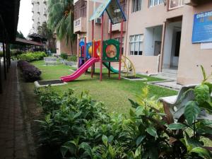 a playground with a slide in a yard at Santorini Home in Tanjung Bungah