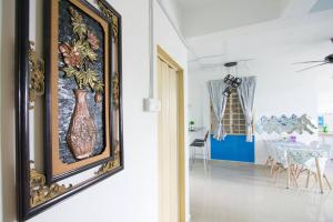 a painting hanging on a wall next to a dining room at Santorini Home in Tanjung Bungah