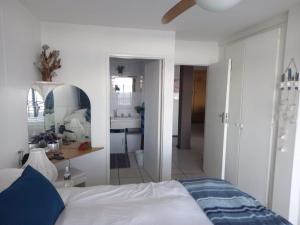 a bedroom with a white bed and a bathroom at Margate - Carmel 1 Lantin At Sea in Margate