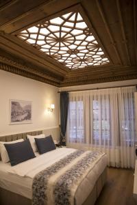 a bedroom with a large bed and a large window at BAYEZİD HAN KONAK in Amasya