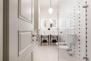 a white bathroom with a toilet and a sink at Luxury 2BDR Heart Of Old Town in Vilnius +43 photos